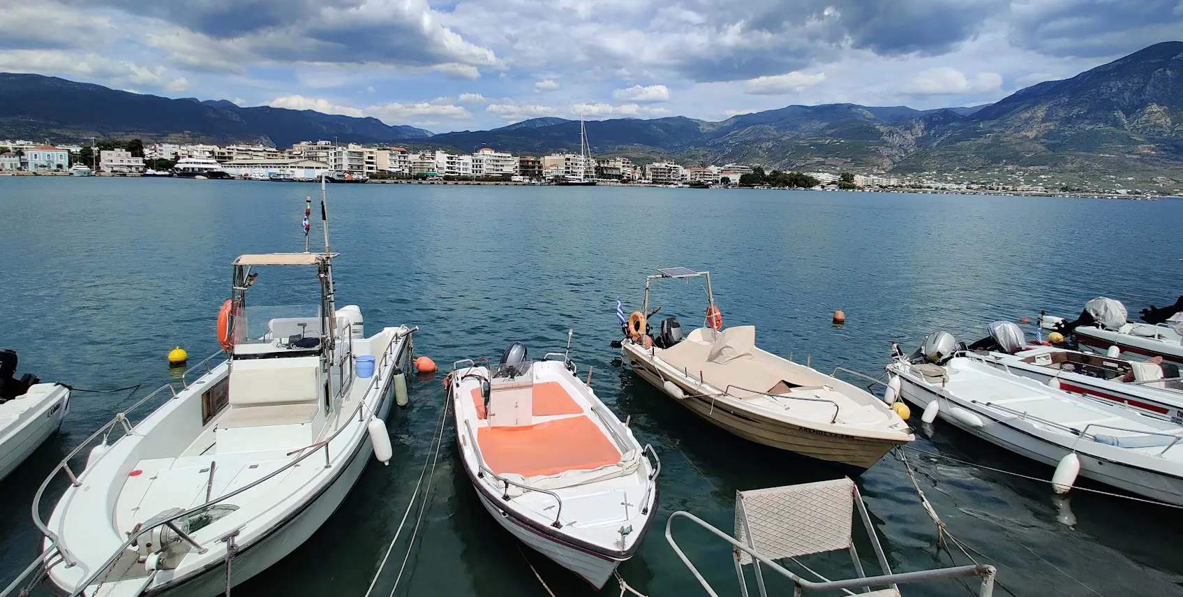 Boote im Hafen von Kalamata mit Uferbebauung und Bergen im Hintergrund