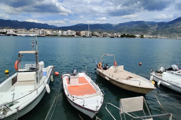Boote im Hafen von Kalamata mit Uferbebauung und Bergen im Hintergrund
